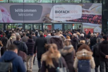 Hundreds of people walking towards the BIOFACH 2019 entrance gate.