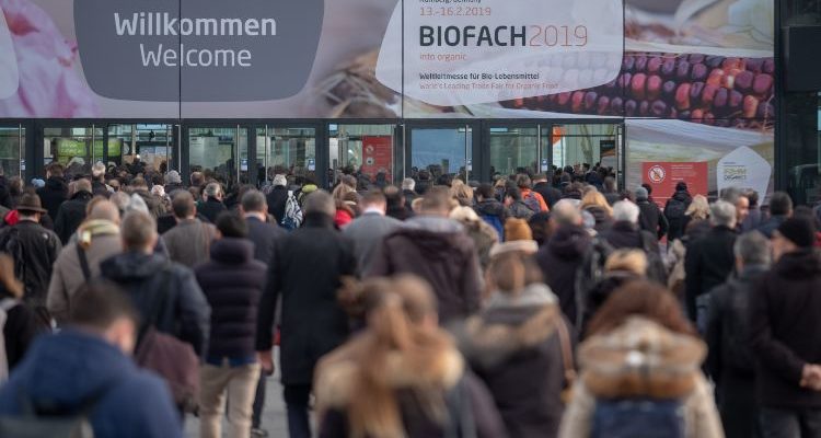 Hundreds of people walking towards the BIOFACH 2019 entrance gate.