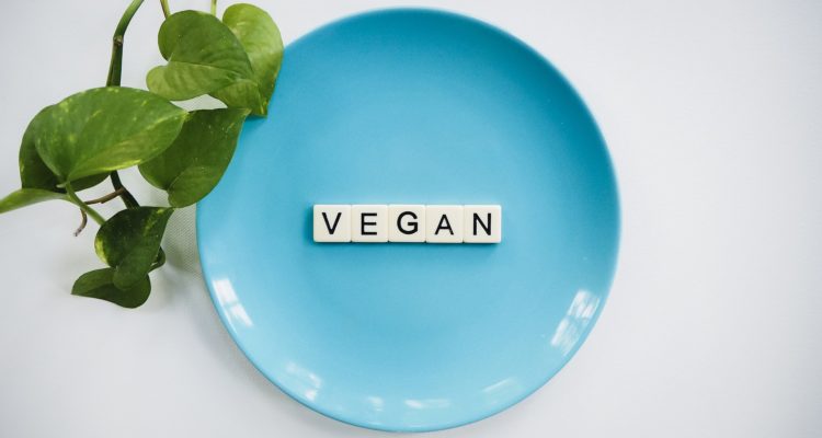 The word 'VEGAN' spelled out on a blue plate -Pure & Eco India